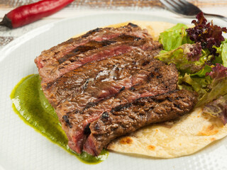flank steak on corn tortilla with spinach sauce