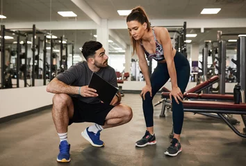 Foto op Plexiglas Male personal trainer discussing fitness workout routine fit woman © JonoErasmus
