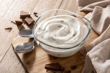 Stracciatella yogurt in transparent bowl on rustic wooden table