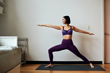 beautiful young woman doing yoga exercises at home