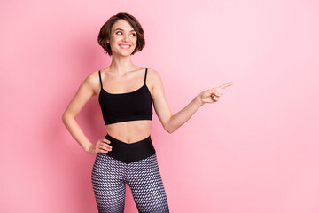Fototapeta na wymiar Photo of nice cheerful young woman look point index finger empty space news gym isolated on pink color background