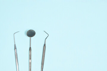 Medical dental instruments on light blue background with copy space. Flat lay close up top view on dental equipment. Tooth care, dental hygiene and health concept.