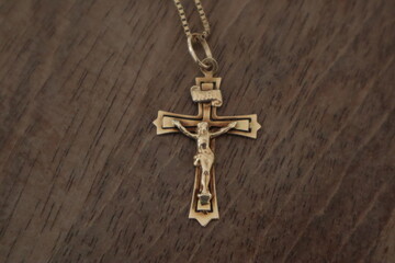 Gold Chain with hanger jesus crusified  cross on a white woorden background