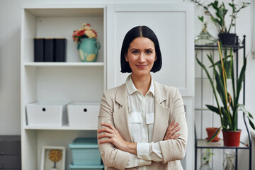 portrait of a beautiful young woman in a white blouse and black suit standing in the office