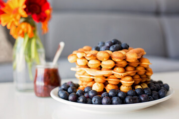 Sweet toddler child, boy, eating bubble waffles with fruits at home for breakfast