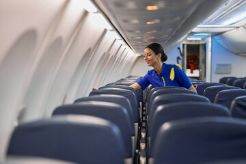 Happy professional stewardess is preparing salon before night fly