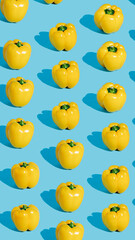 Pattern with fresh yellow bell peppers isolated on pastel blue background. Creative organic vegetable concept. Banner for healthy food or diet. Pop art aesthetic texture.