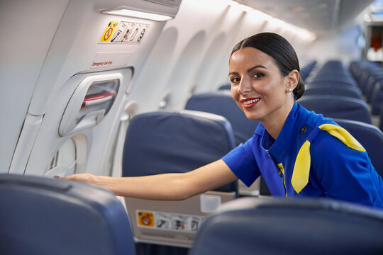 Happy professional stewardess is preparing salon before night fly