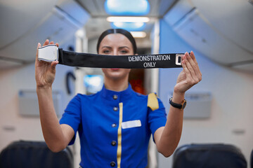 stewardess is showing safety rules before fly at evening plane salon