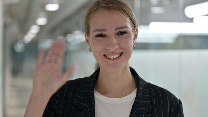 Cheerful Young Businesswoman Waving at the Camera 