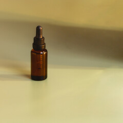 Crystal dropper bottle with essentials oil  on beige background for natural skin care. Modern natural cosmetic