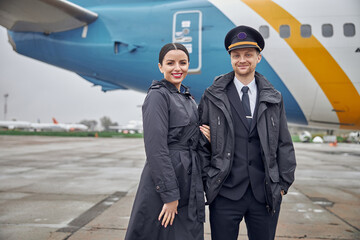 Portrait of happy confident caucasian airplane crew near plane