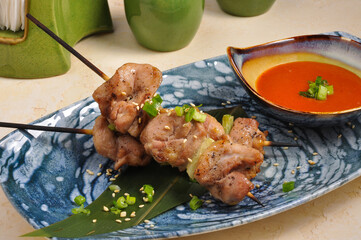 Asian chicken fillet skewer on a bamboo stick with sauce
