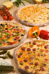assorted three pizzas on a wooden background. Concept: pizza advertising.