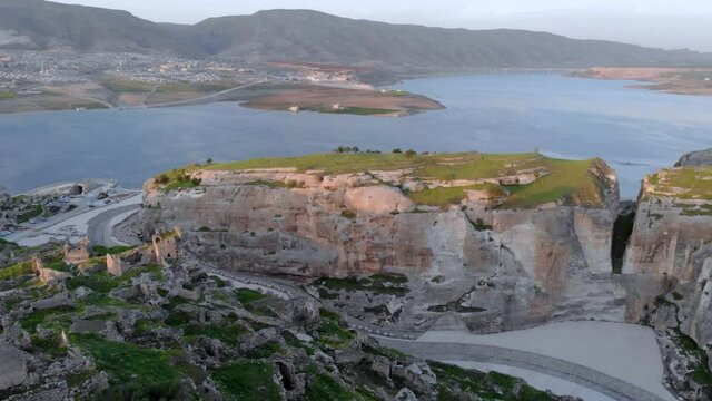 Eastern Turkey, Mesopotamia, the ancient city of Hasankeyf, caves in the rock. Aerial Drone Footage at sunset Time on the Coast of Tigres River