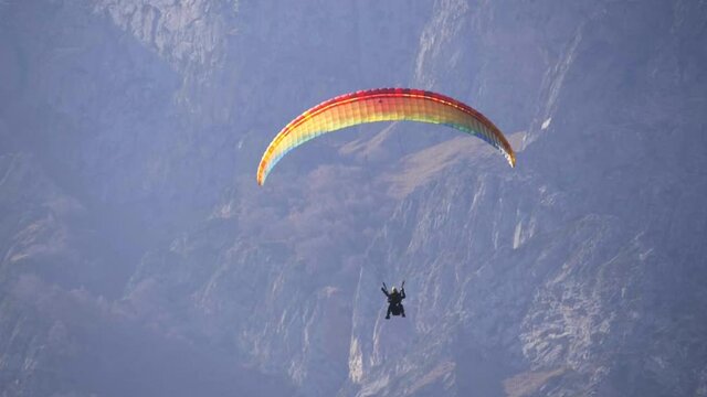 adventure sports video - paragliders flying over mountains on a beautiful sunny day. popular paragliding regions in Europe.