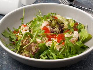 Olivier salad with smoked salmon, red caviar and arugula