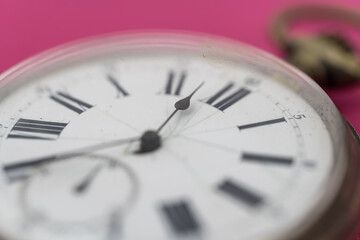 Close up view of old pocket watch on pink background