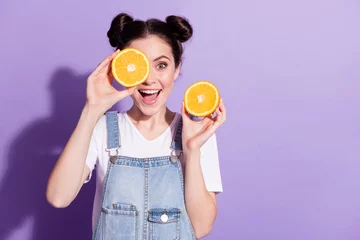 Fotobehang Photo of young attractive girl happy positive smile close cover eye orange fruit isolated over violet color background © deagreez
