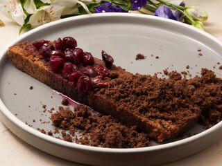 cherry chocolate cake with cherry slices on a grey plate