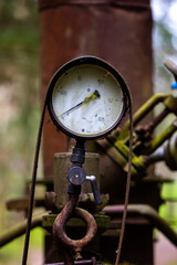 Naklejka premium Pressure gauge on an illegal installation for the production of moonshine (alcohol). Photo taken in low light conditions.