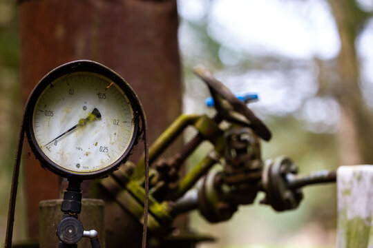 Pressure gauge on an illegal installation for the production of moonshine (alcohol). Photo taken in low light conditions.