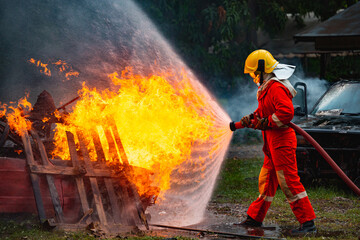 Burning car, Fireman water spray by high pressure nozzle in fire fighting operation  Fire and Firefighter training school.
