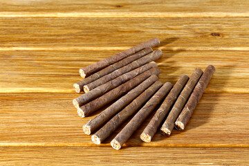 Cigarillos lie on a table made of old wooden boards