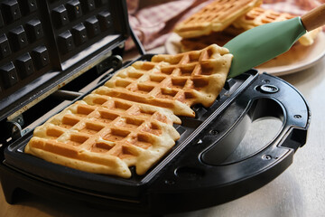 waffles are baked waffle iron machine. close up - obrazy, fototapety, plakaty