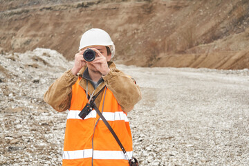 mining or road engineer using a telescope against the background of a mine