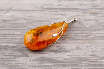 Pendant in silver of whole amber, with inclusions of ancient fauna.
