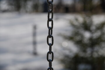 Metallic brushed chain on a white background. Part of the links of an iron gray chain with a...