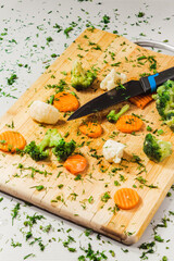 Assorted vegetables on a cutting board on a white table background, for a healthy lifestyle.