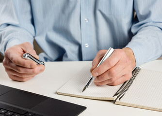 Man at the computer with an ink pen. © Natalia