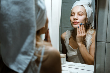 Use Wash Off Face Mask, Using Peel-Off Mask Correctly. Young woman in towel on her head wash face after removing mask in bathroom.