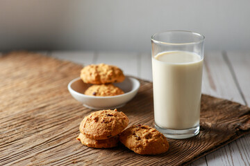 A fresh glass of milk with chocolate chip cookies on white wooden background. Healthy eating. Selective focus.