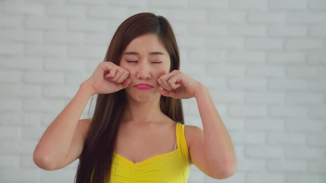 A woman pretend to cry and regret her boyfriend for the man to reconcile her. Expressing emotion portrait in front of the camera.