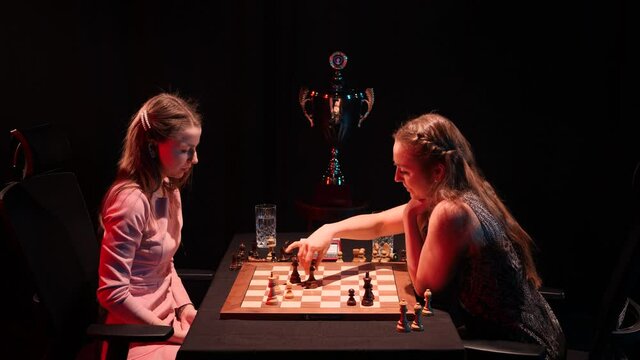 Two attractive young women play final match of professional chess