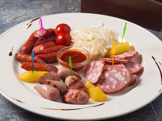 assorted sausages for beer on a white plate