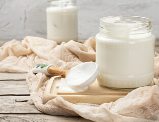 Obraz na płótnie Canvas homemade yogurt in a glass transparent jar on a wooden table