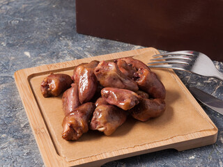 chicken hearts cooked smoked on a wooden Board