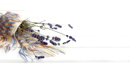 Obraz na płótnie Canvas small twigs with flowers lavender tied with a knitted scarf. aromas of warm feelings