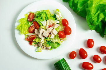 Healthy food, salad with chicken, cherry tomatoes, green, on a white background, in a close-up, isolated
