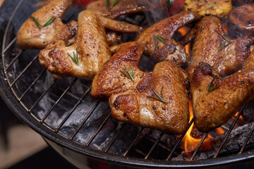 Grilled chicken wings on the flaming grill with Grilled vegetables in barbecue sauce with pepper seeds rosemary, salt. top view with copy space. tasty snack. Flat lay. Healthy lunch menu. Diet food.