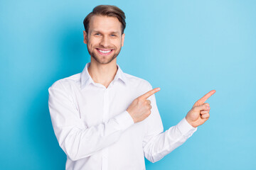 Photo of cheerful positive happy man point fingers empty space sale discount isolated on blue color background