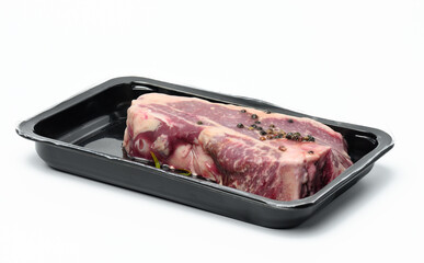 Raw New York beef steak is packed in a plastic container and vacuum sealed