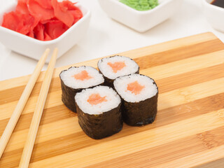 sushi roll with salmon in nori seaweed on a wooden Board