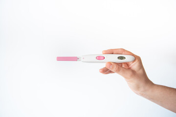 young woman holding with one hand a positive fertility test, on white background. pregnancy concept.