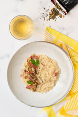 Risotto with mushrooms, green tea and italian speck. White background and yellow towel