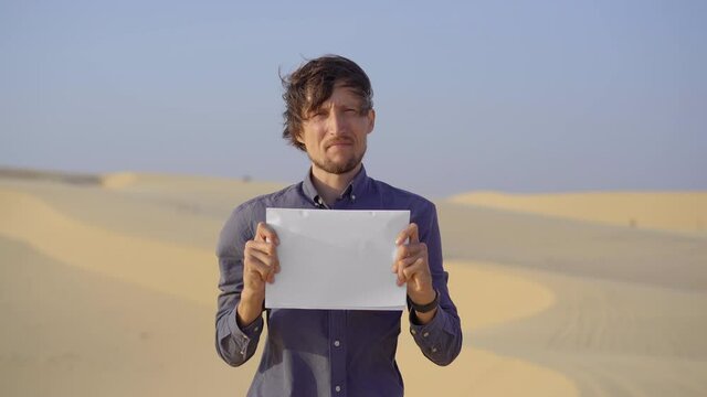 A man standing in a desert holds a blank white sheet in front of him. REduce carbon emissions. Stop climate change